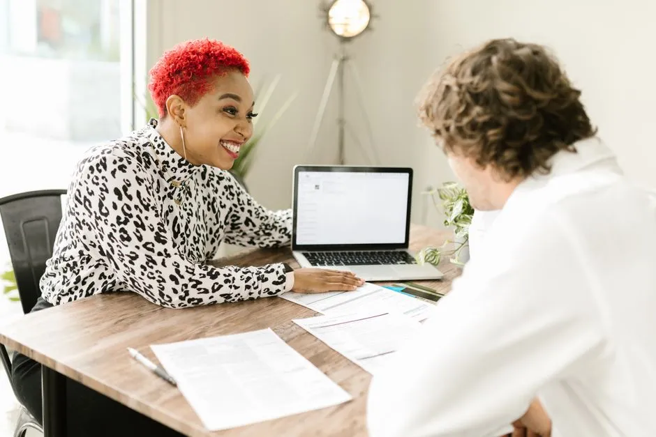 Un chef d'entreprise feuillette des lettres de mission d'experts-comptables dans un bureau lumineux